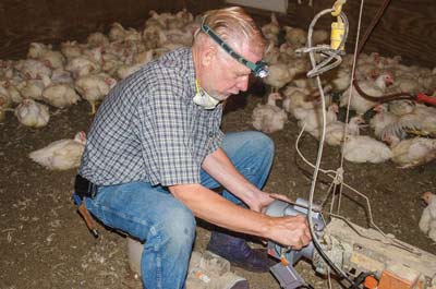 Calvin Becker replaces a feed-line motor in a broiler house.