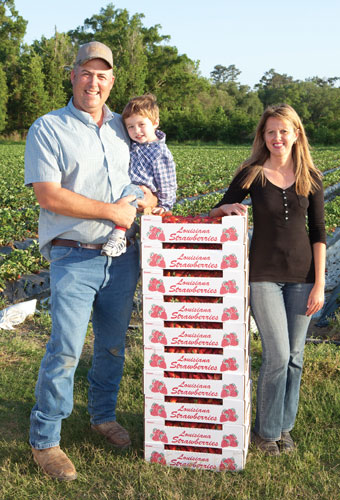 The Morrow family with boxes of strawberries