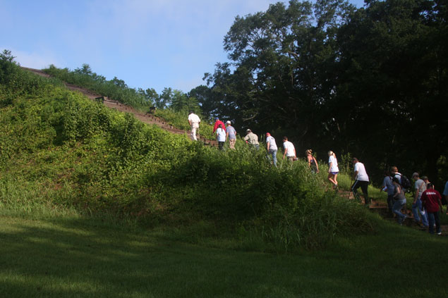 Students hiking up a mound