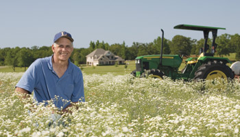 Larry Rhea smiling near a tractor