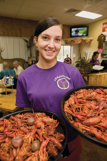 girl holding plates of crawfish