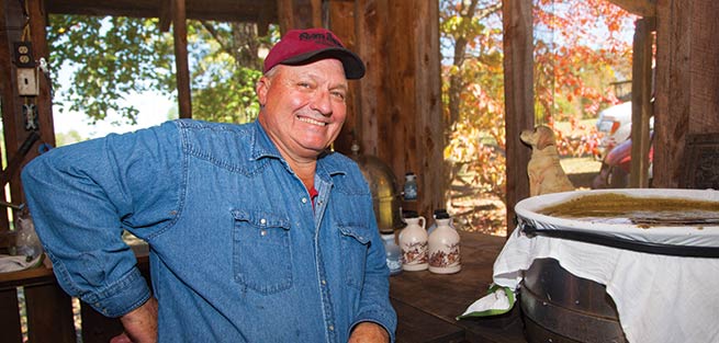 Terry Norwood, a man, strains syrup.