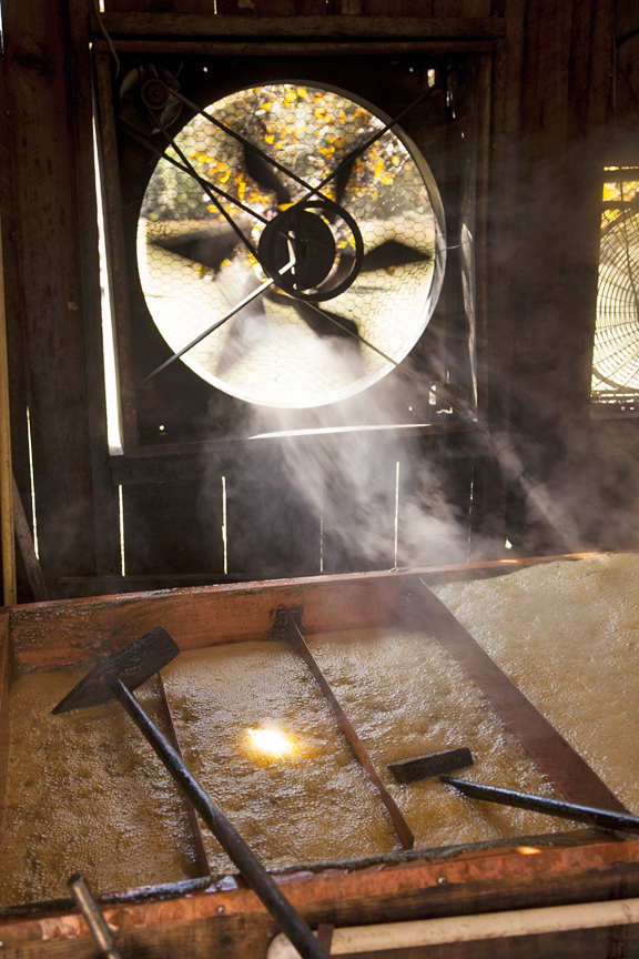 A fan draws the steam off the boiling sorghum juice
