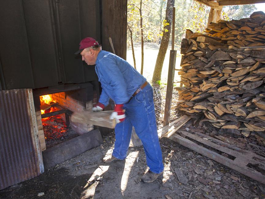 Terry feeds the firebox at the cooking shed
