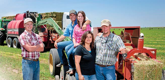 The Carthel family near some baling equipment