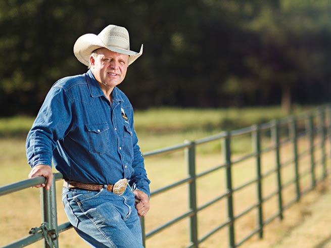 Cody Lambert leans against a fence.