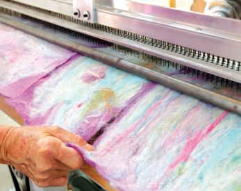 Multicolored pastel alpaca fiber in a giant comb machine