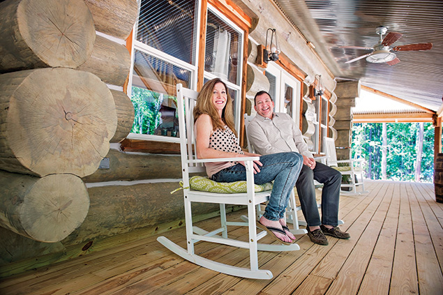 Susan and Chris Strohm on the front porch of their log home