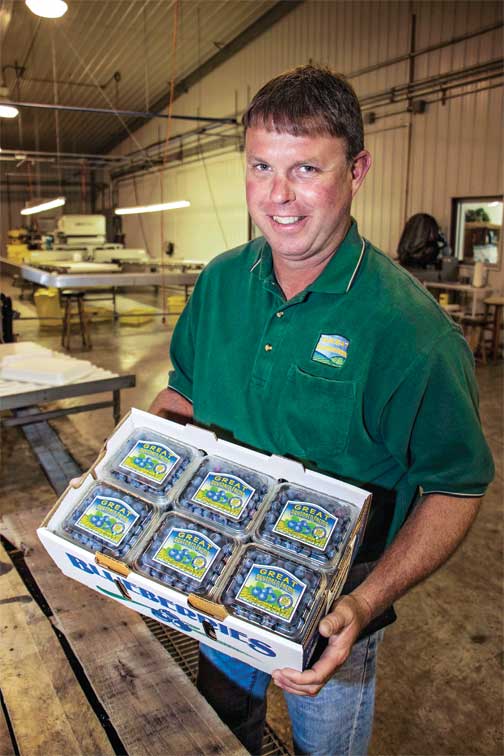 Jeremy Edwards holds packaged blueberries