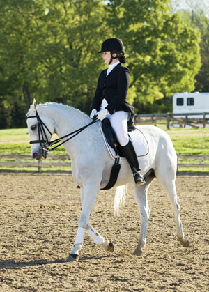 Rider with helmet on a white horse