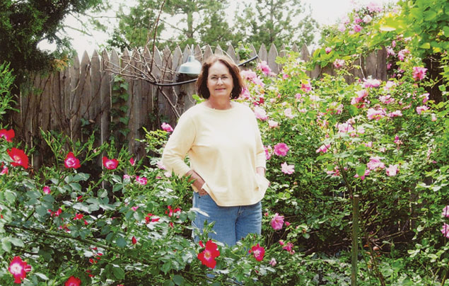 Nell Rains standing among flowers