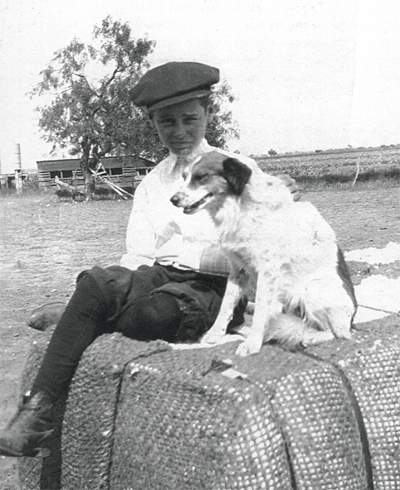 A boy and his dog on a bale of cotton in Runnels County, Texas - 1920s