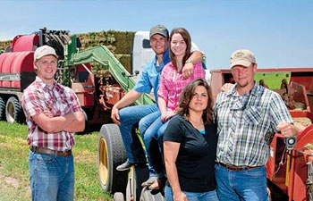 The Carthel family near some baling equipment