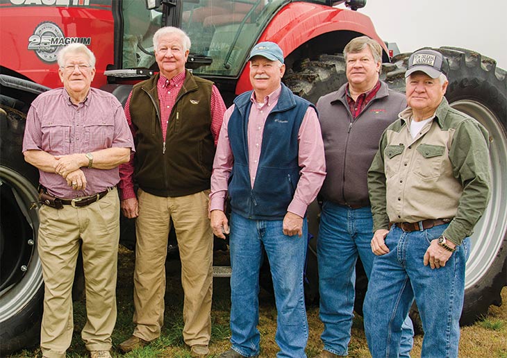 The Marsh brothers in front of a giant red tractor