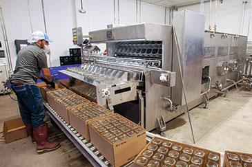 A worker cleans glass bottles