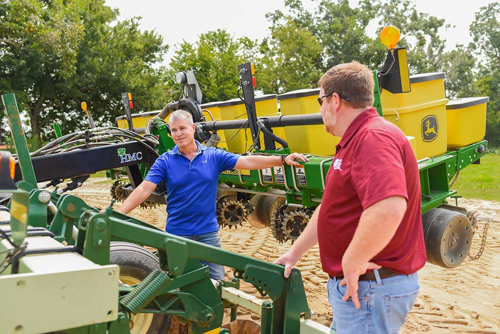 photo of Wade Helms explaining his invention to Justin Jernegan, Alabama Ag Credit’s Dothan branch manager.