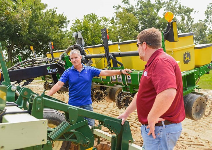 photo of Wade Helms explaining his invention to Justin Jernegan, Alabama Ag Credit’s Dothan branch manager.