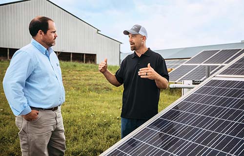 Matt Lee and Chuck Roberts standing near solar panels