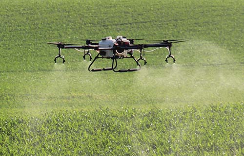 One of Hylio's drones sprays above a field