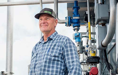 Sieto Mellema standing next to methane digester equipment