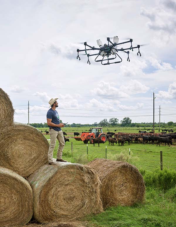 Erickson operates one of the larger drones near hay bales and cattle